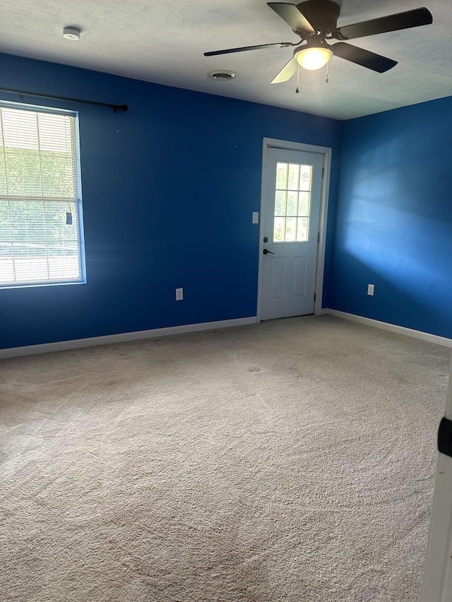 empty room featuring baseboards, visible vents, ceiling fan, a textured ceiling, and carpet floors