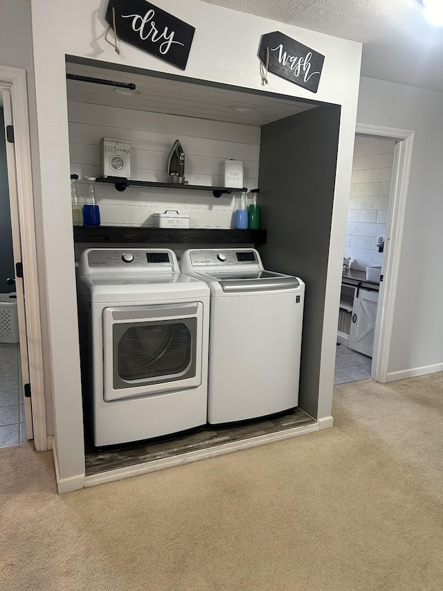 clothes washing area featuring laundry area, washing machine and clothes dryer, and light colored carpet