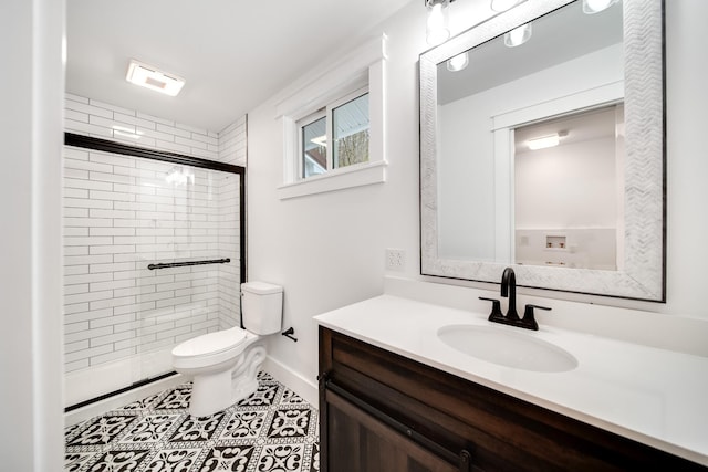 bathroom with tile patterned flooring, vanity, an enclosed shower, and toilet