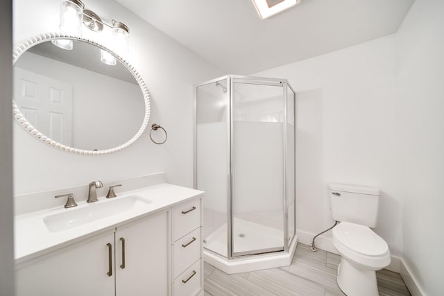 bathroom with vanity, a shower with door, and toilet