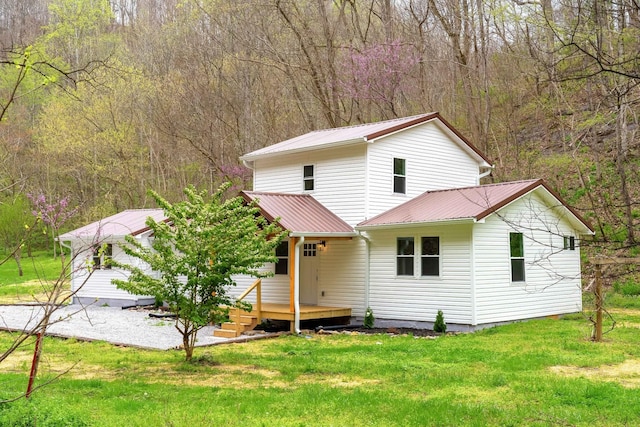 back of house with a wooden deck and a lawn