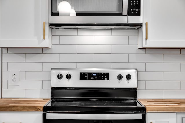 details featuring wood counters, decorative backsplash, stainless steel appliances, and white cabinets