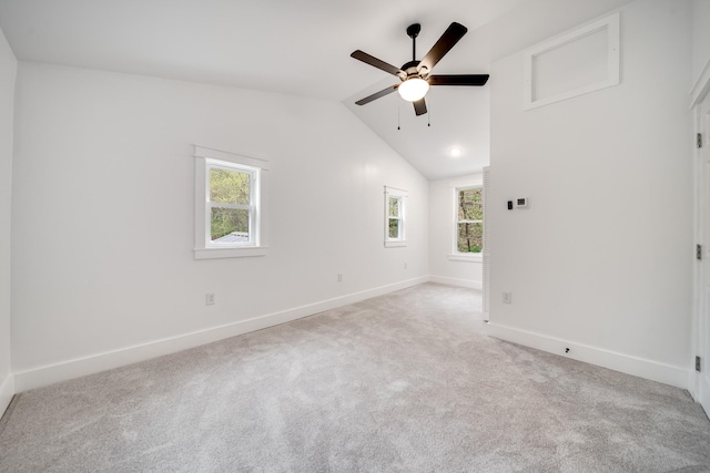 empty room with vaulted ceiling, light colored carpet, and ceiling fan