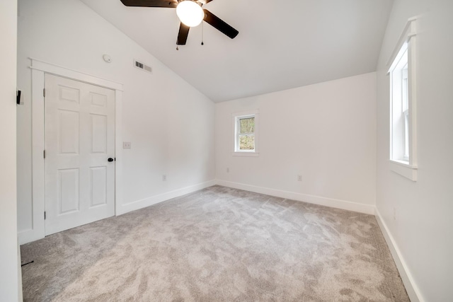 empty room with ceiling fan, lofted ceiling, and light carpet