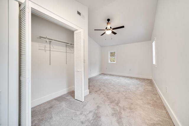 unfurnished bedroom with lofted ceiling, light colored carpet, ceiling fan, and a closet