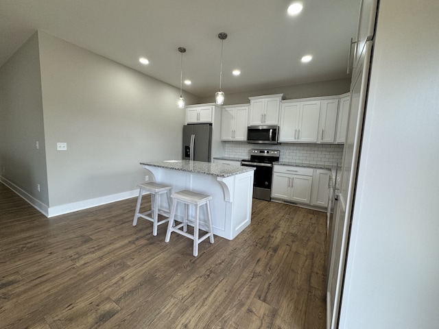 kitchen featuring white cabinets, appliances with stainless steel finishes, a center island, dark hardwood / wood-style flooring, and decorative backsplash