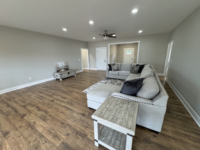 living room featuring ceiling fan and dark hardwood / wood-style flooring