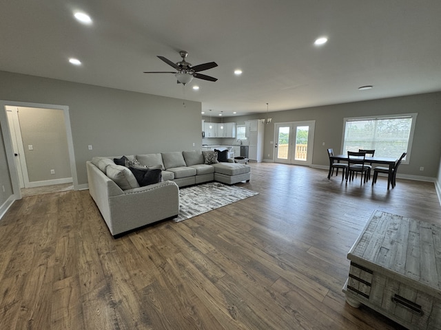 living room featuring dark wood-type flooring and ceiling fan