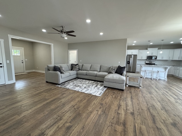 living room featuring ceiling fan and hardwood / wood-style flooring