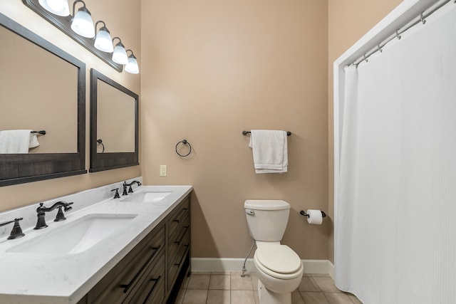 bathroom with double vanity, toilet, and tile patterned floors