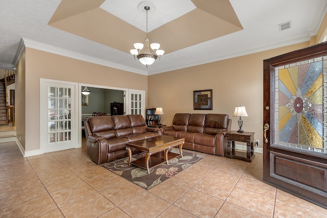 living room with ornamental molding, an inviting chandelier, light tile patterned floors, and a tray ceiling