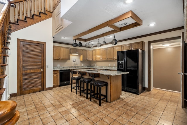 kitchen featuring a breakfast bar, a kitchen island, beamed ceiling, black appliances, and sink