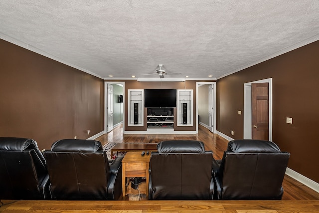 cinema with dark hardwood / wood-style floors, ceiling fan, ornamental molding, and a textured ceiling