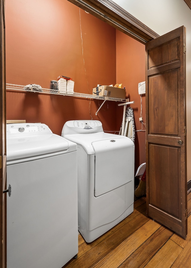 laundry room with washing machine and dryer and light wood-type flooring