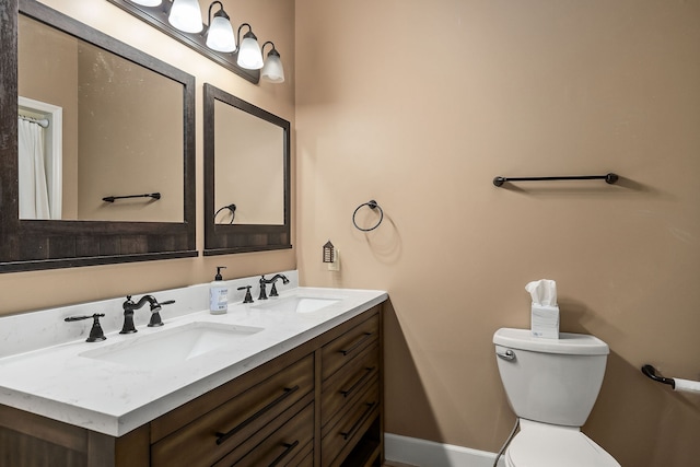 bathroom with toilet and double sink vanity