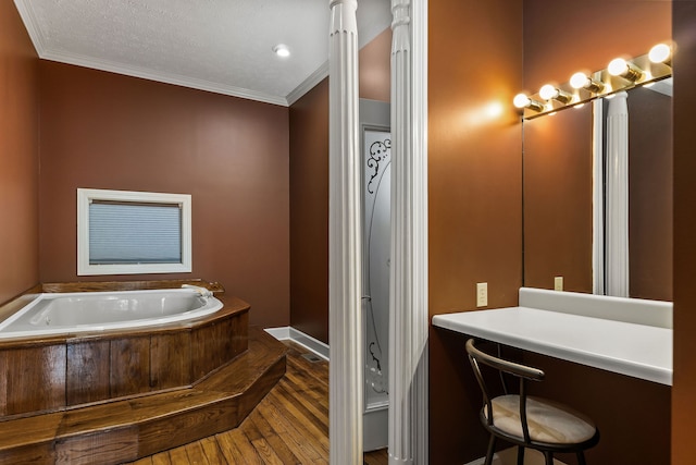 bathroom with hardwood / wood-style flooring, a bath, crown molding, and a textured ceiling