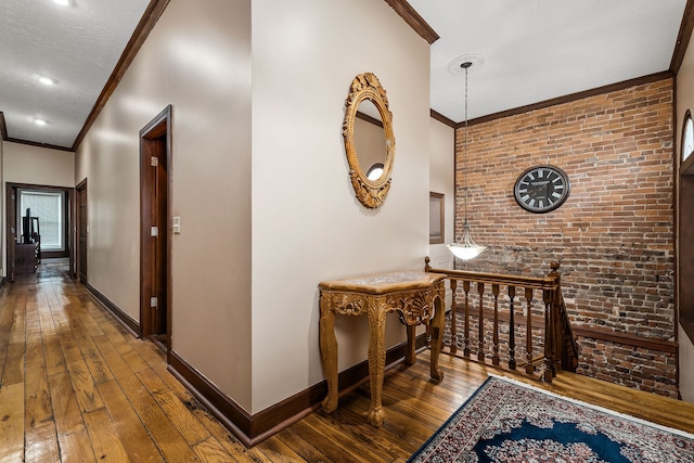 hallway with brick wall, crown molding, and hardwood / wood-style floors