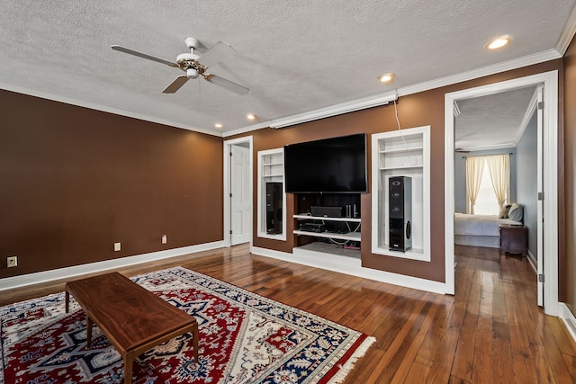 living room featuring wood-type flooring, a textured ceiling, ceiling fan, and crown molding