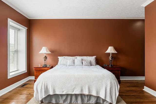 bedroom featuring wood-type flooring, multiple windows, and a textured ceiling