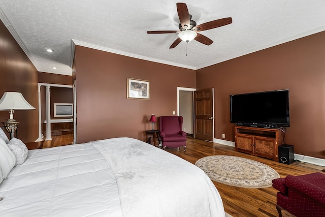 bedroom featuring ornamental molding, a textured ceiling, ceiling fan, and hardwood / wood-style floors