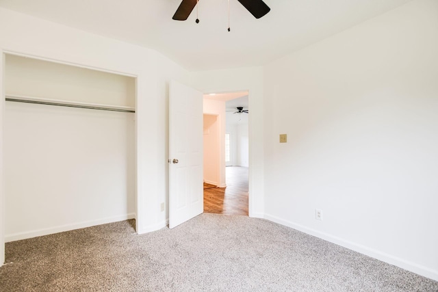 unfurnished bedroom featuring carpet, baseboards, ceiling fan, and a closet