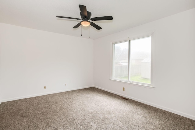 carpeted empty room featuring visible vents, baseboards, and ceiling fan