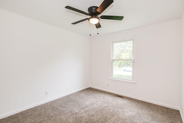 carpeted empty room with visible vents, baseboards, and ceiling fan