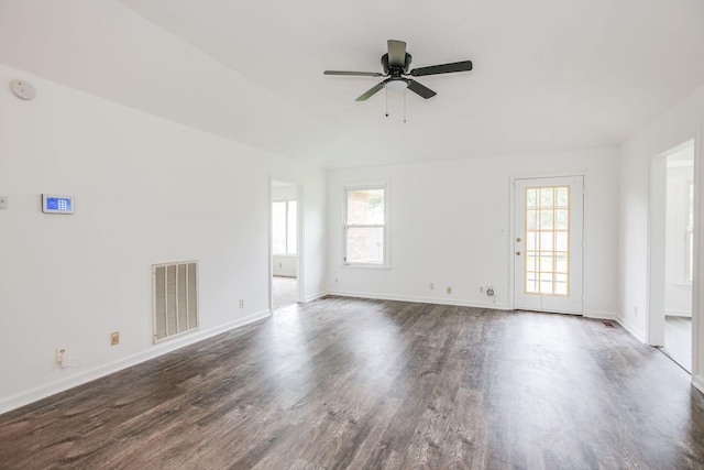 spare room featuring a healthy amount of sunlight, visible vents, and dark wood-style flooring