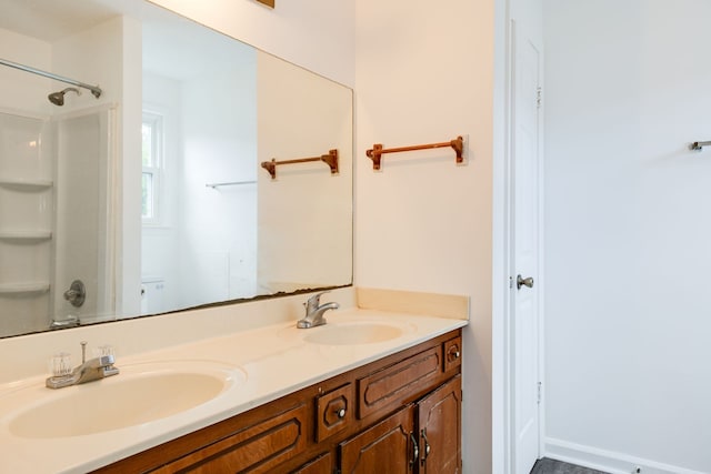 bathroom featuring a shower, toilet, and vanity