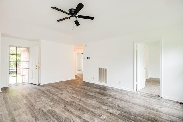 unfurnished living room with a ceiling fan, wood finished floors, visible vents, and baseboards