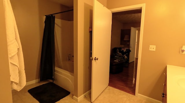 full bathroom with vanity, shower / bathtub combination with curtain, baseboards, and tile patterned floors