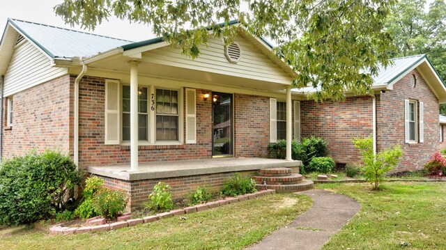 ranch-style house featuring a front lawn and covered porch