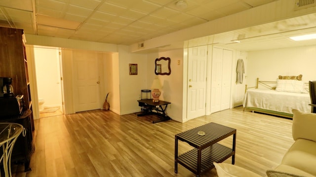 bedroom with wood finished floors, visible vents, and baseboards