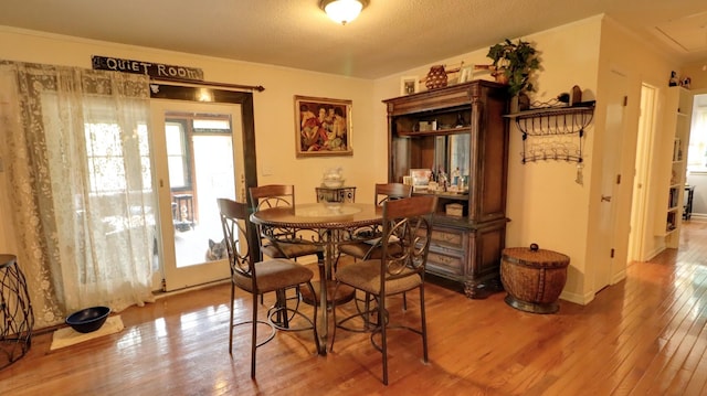 dining room featuring attic access, baseboards, and wood finished floors