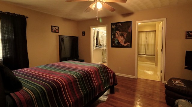 bedroom featuring ceiling fan, baseboards, wood finished floors, and ensuite bathroom