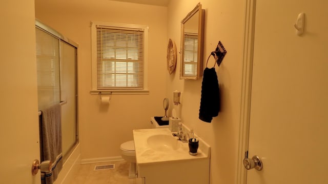 bathroom featuring visible vents, toilet, enclosed tub / shower combo, vanity, and baseboards