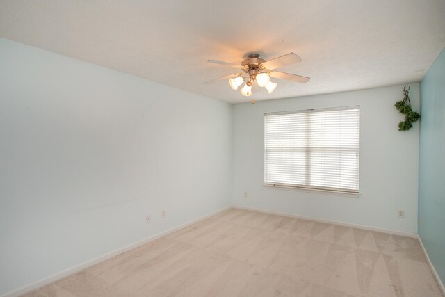 empty room with ceiling fan and light colored carpet