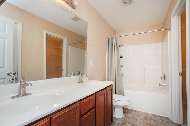 full bathroom featuring a textured ceiling, toilet, shower / tub combo with curtain, tile patterned floors, and double vanity