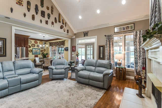 living room featuring wood-type flooring, crown molding, french doors, and high vaulted ceiling