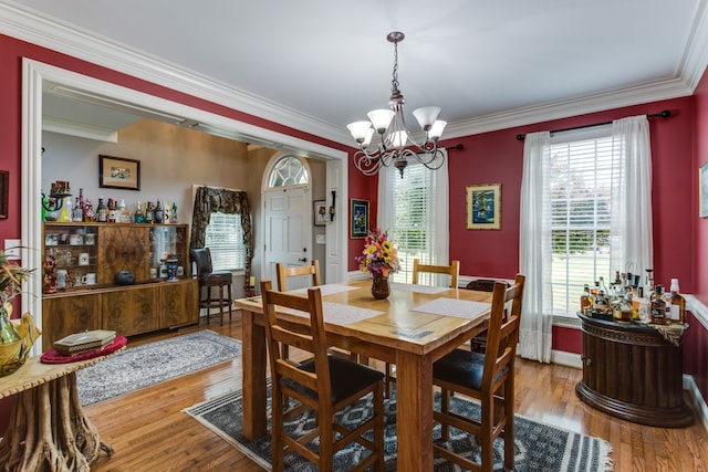 dining room featuring light hardwood / wood-style flooring, a chandelier, and ornamental molding