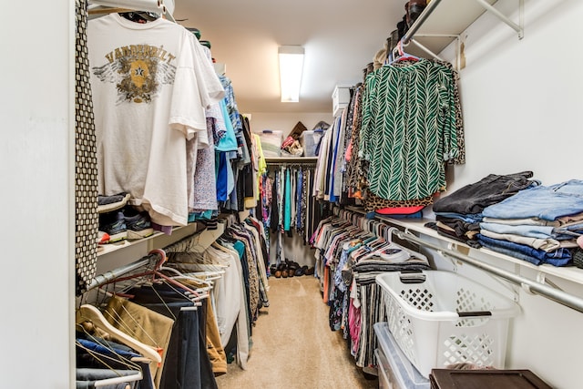 walk in closet featuring light colored carpet