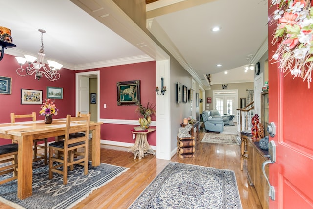 dining room with an inviting chandelier, crown molding, and hardwood / wood-style flooring