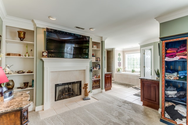 carpeted living room featuring ornamental molding, a tile fireplace, and built in features