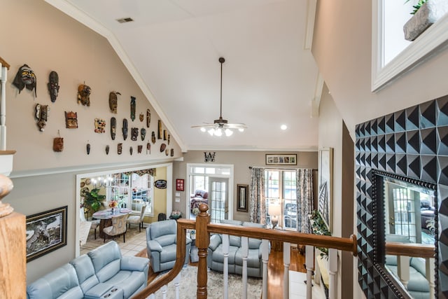 tiled living room with ornamental molding, ceiling fan, and high vaulted ceiling