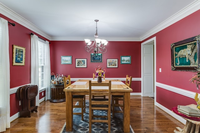 dining space with wood-type flooring, ornamental molding, and an inviting chandelier