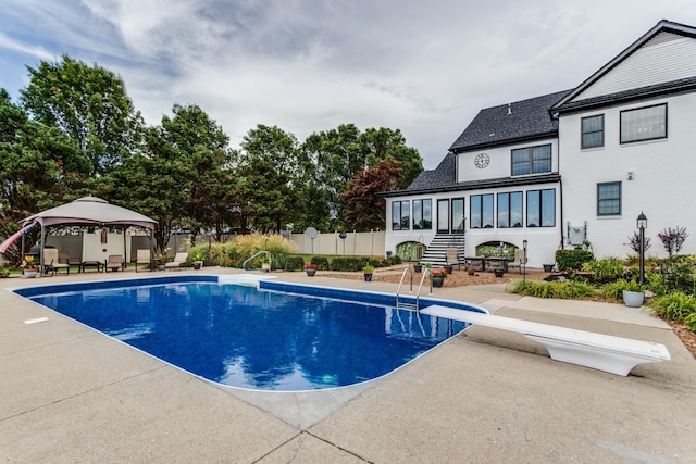 view of pool featuring a patio, a gazebo, and a diving board