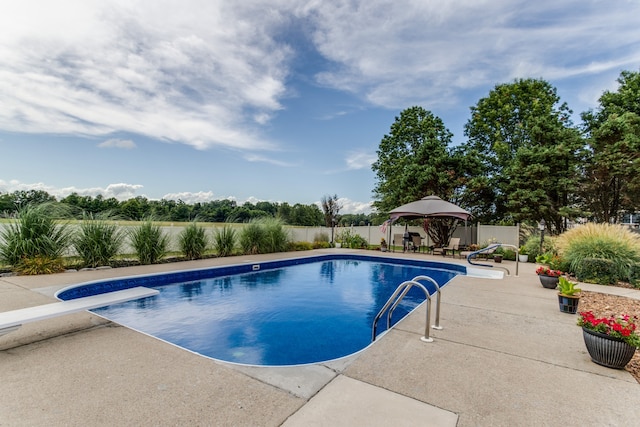 view of swimming pool with a patio and a diving board