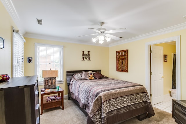 bedroom featuring light carpet, ensuite bathroom, ceiling fan, and crown molding