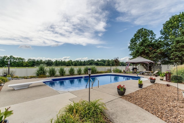 view of pool with a patio, a gazebo, and a diving board