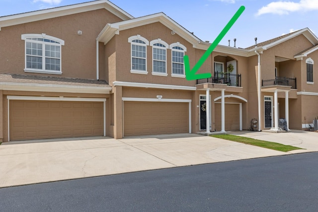 view of property featuring a balcony and a garage